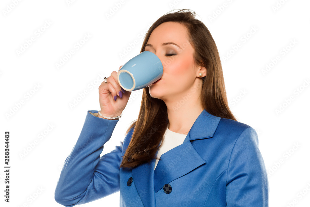 Fototapeta premium Young business woman drink from a mug on white background
