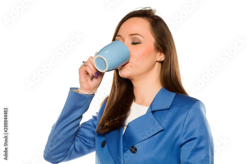 Young business woman drink from a mug on white background