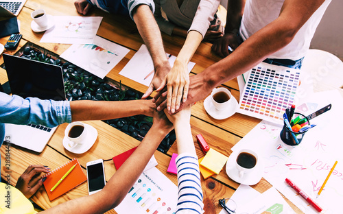 Group of happy, excited and successful modern people in office. Start up business team are holding hands together in circle. Company of young students are celebrating some win. 