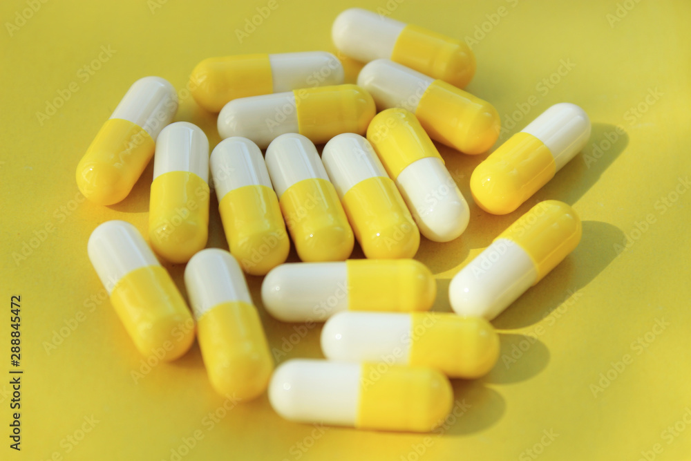 Yellow-white capsules on a yellow background. Yellow-white capsules on a yellow background.