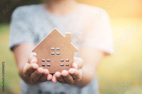 Small home model on woman hand.