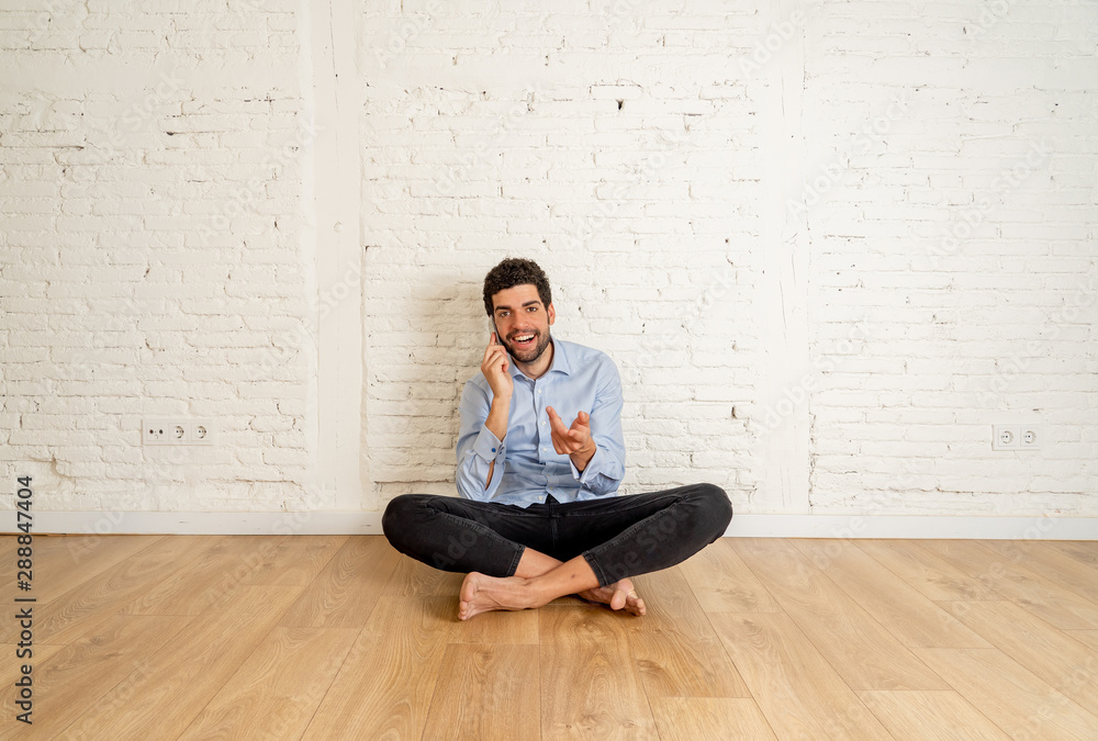 Hipster young man talking on mobile phone happy in his new empty apartment proud of his investment Hipster young man talking on mobile phone happy in his new empty apartment proud of his investment