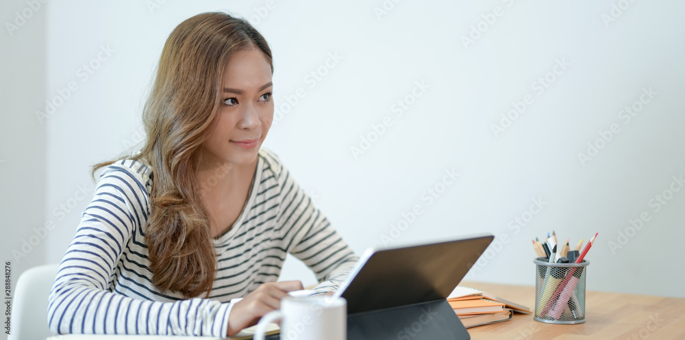 Young professional graphic designer working on her project with tablet Young professional graphic designer working on her project with tablet