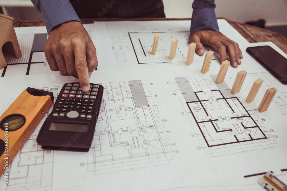 Architect Engineer using calculator Estimate construction drawings with