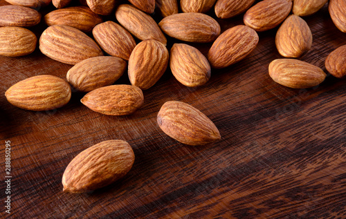 Almond. Peeled almonds on wooden background.