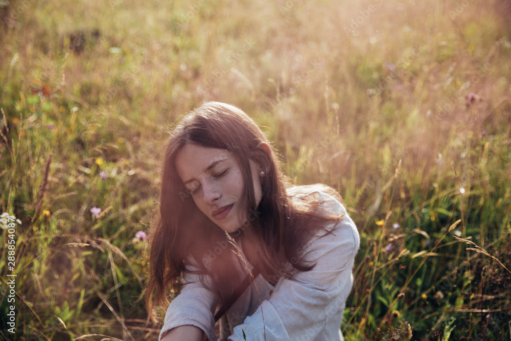 Woman enjoying nature and sunlights in meadow and flowers . Field at sunrise. Woman enjoying nature and sunlights in meadow and flowers . Field at sunrise.