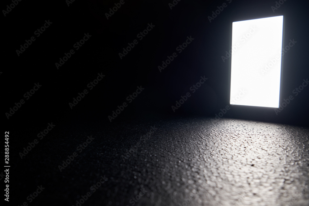 The white screen of the smartphone glows on a black background. The white screen of the smartphone glows on a black background.