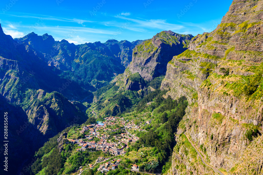 View from Eira do Serrado to Curral das Freiras village in the Nuns Valley in beautiful mountain scenery, municipality of Câmara de Lobos, Madeira island, Portugal. View from Eira do Serrado to Curral das Freiras village in the Nuns Valley in beautiful mountain scenery, municipality of Câmara de Lobos, Madeira island, Portugal.