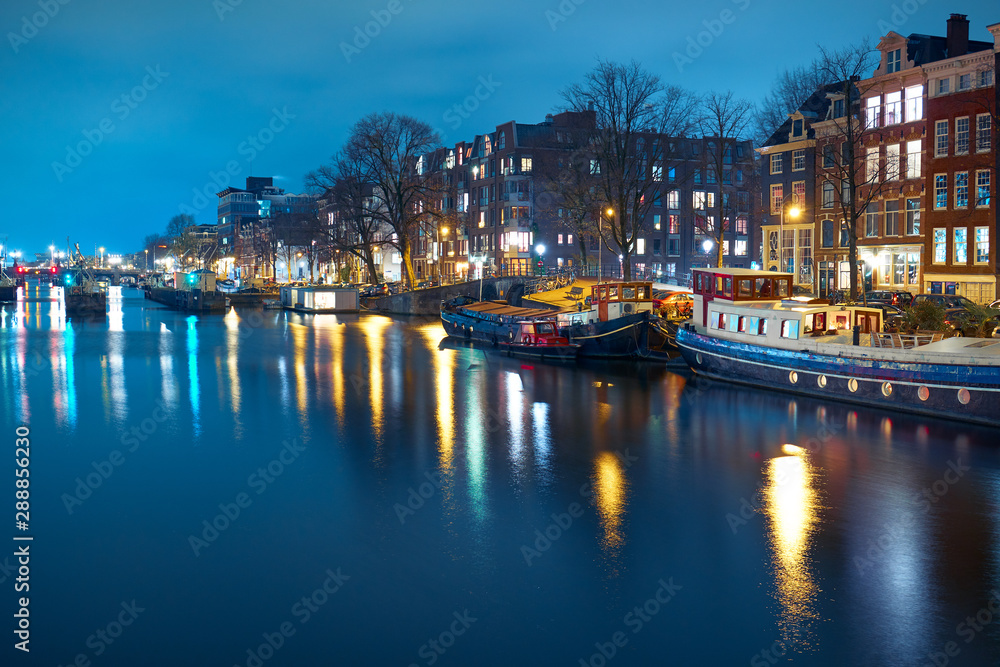 City landscape. Houseboat in the tourist area of Amsterdam at night.