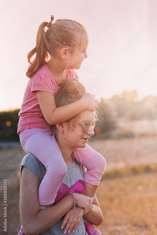 Young girl carrying sister giving piggyback ride Stock Photo