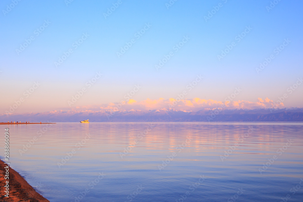 Beautiful sunset on a lake in the mountains. Kyrgyzstan, Issyk-Kul Lake. Bright sky, background in warm colors. Beautiful sunset on a lake in the mountains. Kyrgyzstan, Issyk-Kul Lake. Bright sky, background in warm colors.