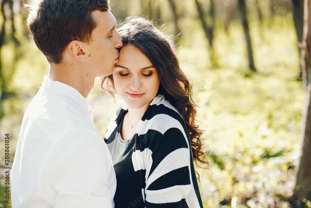 bright and happy pregnant woman walking in the park with her husband bright and happy pregnant woman walking in the park with her husband