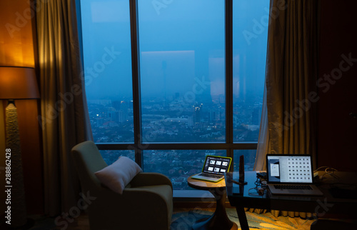 View of megapolis city from inside a hotel room at night. Amazing view through window.