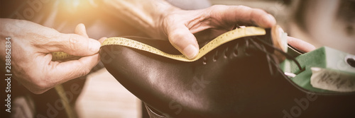 Close up of cobbler measuring a shoe photo