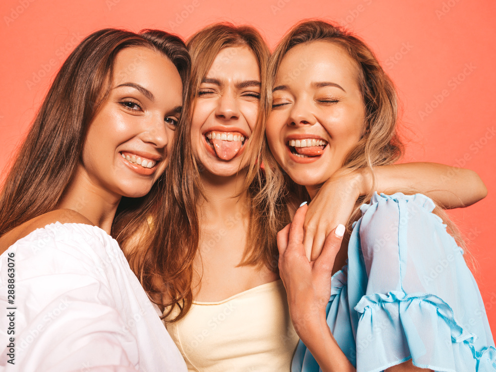 Portrait Of Teen Girlfriends Posing With New Clothes. Group Of Three Happy  Smiling Young Beautiful Women Shopping Together, Standing In Mall, Holding  Hangers With Different Dresses, Showing Thumbs Up Stock Photo, Picture