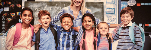 Fotografía Happy teacher standing with schoolkids in classroom