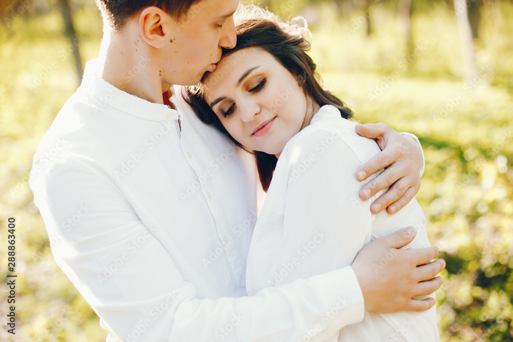 Fototapeta premium bright and happy pregnant woman walking in the park with her husband