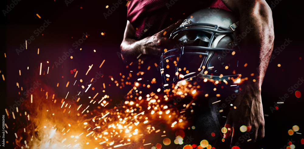 Mid section of sports player holding helmet Mid section of sports player holding helmet