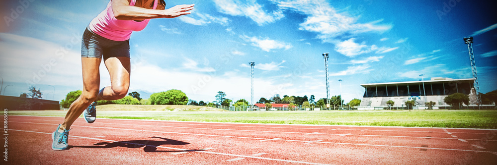 Naklejka premium Female athlete running on running track