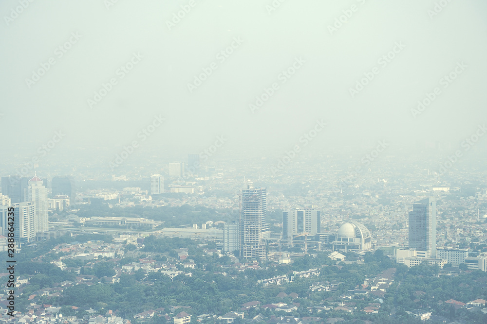 View of a modern city skyline covered in a dense smog and pollution.