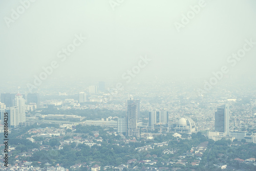 View of a modern city skyline covered in a dense smog and pollution.