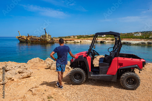 Pathos. Island of Cyprus. Motorcycle.Travel to the remains of a ship in Cyprus.A man on the beach of Paphos.Human next to the ATV.A man admires the view of the old ship.ATV driver stands with his back