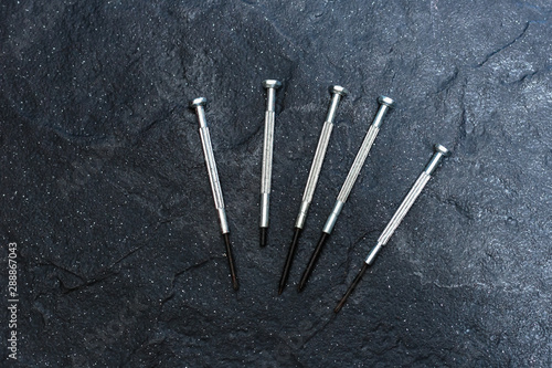 A set of screwdrivers on a black stone. Close-up.
