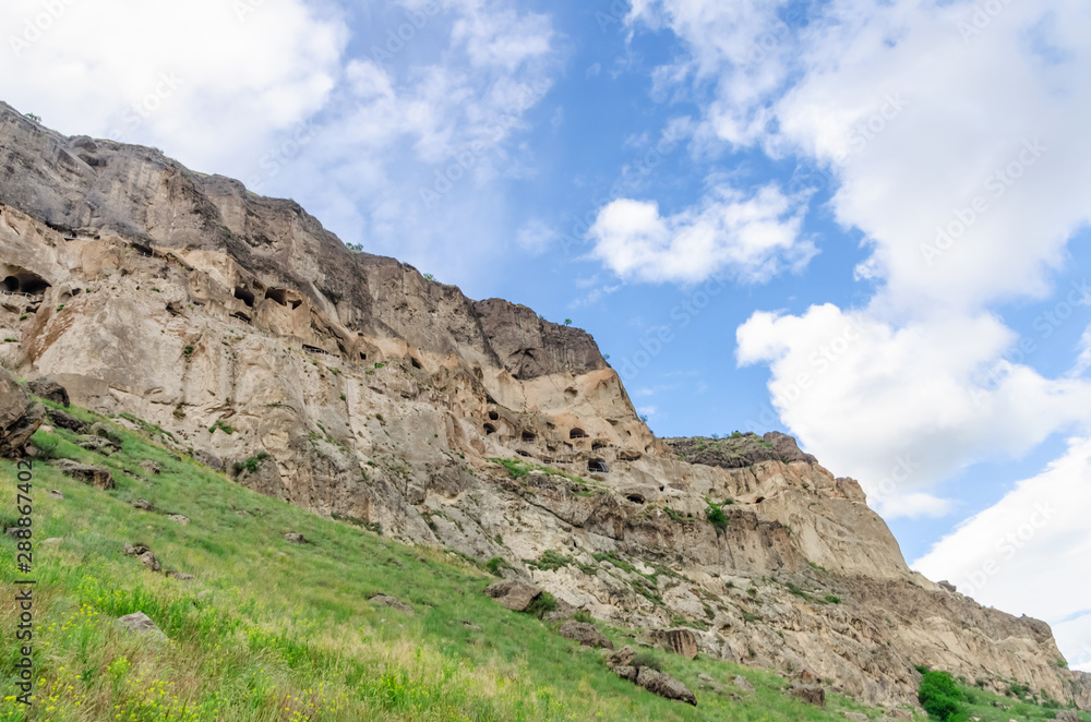 View of the Vardzia caves against the sky with clouds. Vardzia is a cave monastery in southern Georgia View of the Vardzia caves against the sky with clouds. Vardzia is a cave monastery in southern Georgia