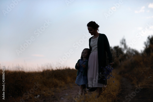 Mother with daughter walking on a road © alexkich