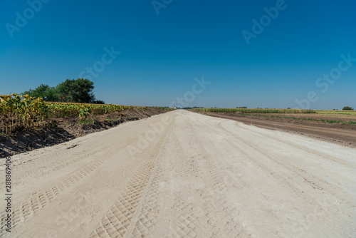 Machines work on the construction of a new road  trodden sand