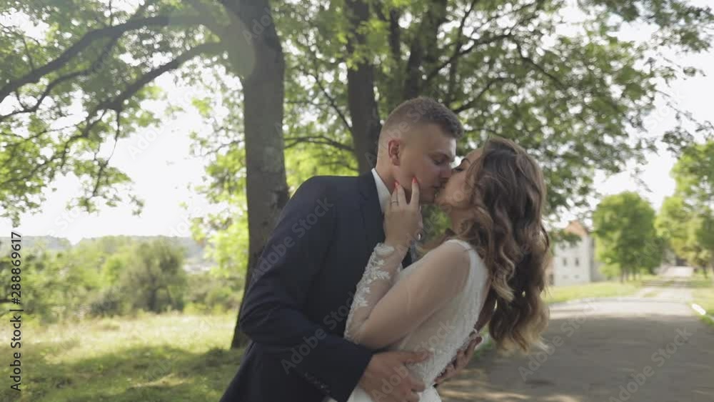 Caucasian groom with bride in the park. Wedding couple. Newlyweds kissing Caucasian groom with bride in the park. Wedding couple. Newlyweds kissing