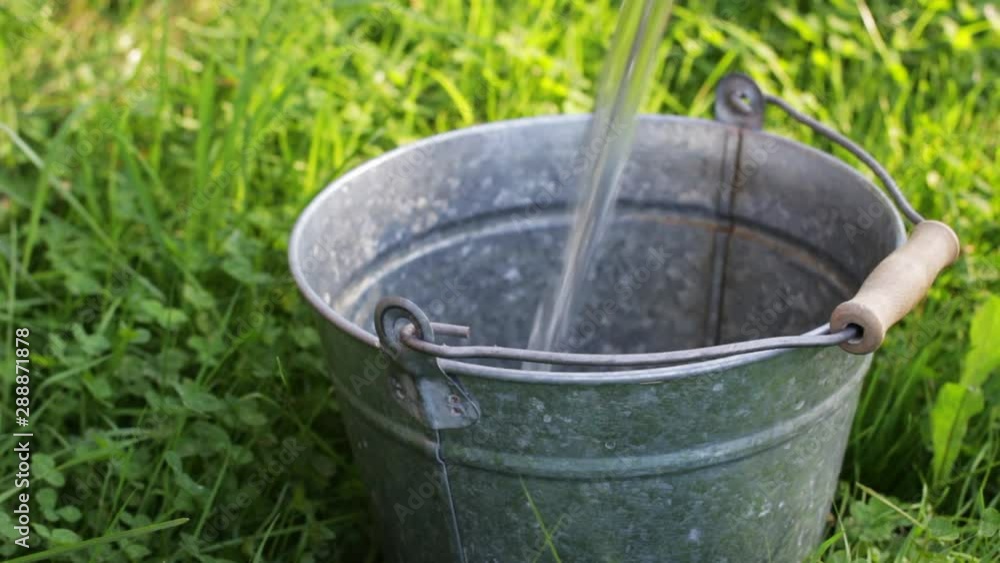 Bottomless metal bucket is endless fills with water, video looped Bottomless metal bucket is endless fills with water, video looped