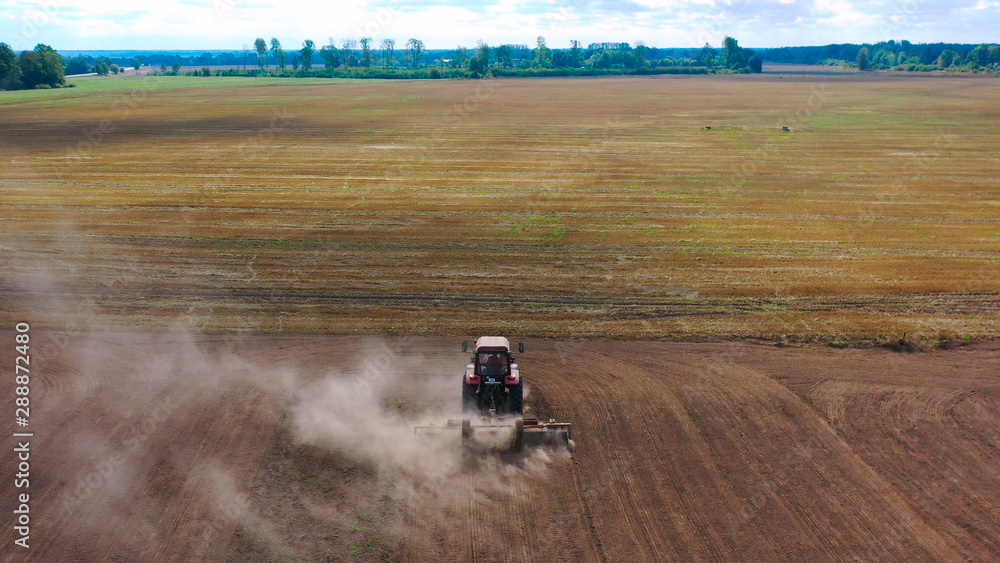 Aerial view drone of harvest field with tractor mows dry grass. Autumn yellow field with a haystack after harvest top view. Harves. Ting in the fields. Stock up Aerial view drone of harvest field with tractor mows dry grass. Autumn yellow field with a haystack after harvest top view. Harves. Ting in the fields. Stock up