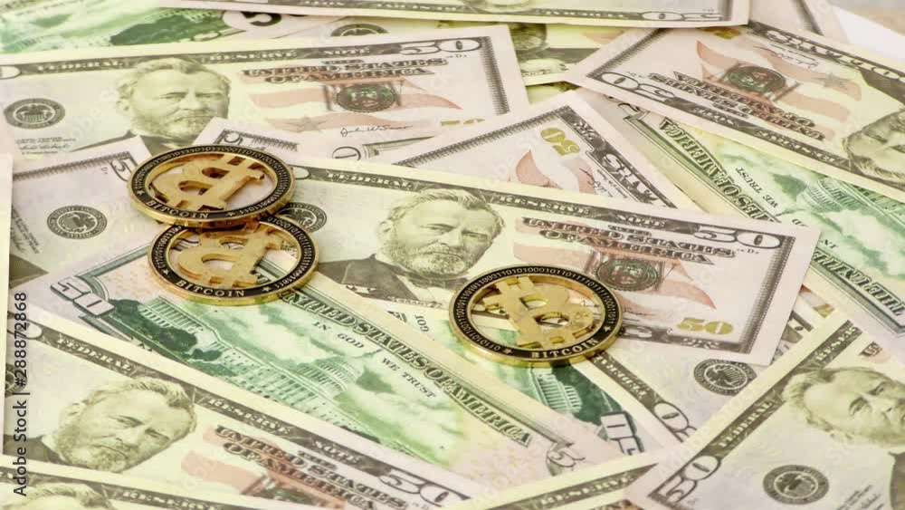 Gold Bit Coin BTC coins rotating on bills of 50 dollars. Worldwide virtual internet cryptocurrency. Gold Bit Coin BTC coins rotating on bills of 50 dollars. Worldwide virtual internet cryptocurrency.