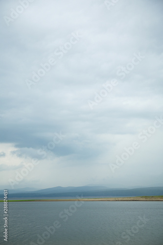 clouds with rain in the mountains and above the water