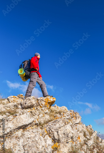 Photographer on top of the mountain in autumn. Traveler with backpack enjoying a view from the mountain top