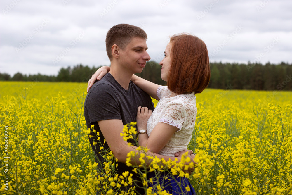 Beautiful couple in a yellow rapeseed field Beautiful couple in a yellow rapeseed field