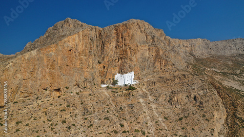 Aerial drone photo of breathtaking whitewashed holy Monastery of Panagia Hozoviotissa built in a steep cliff overlooking the Aegean deep blue sea, Amorgos island, Cyclades, Greece