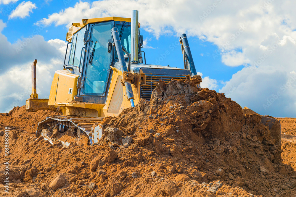Crawler bulldozer - excavator with clipping path on a background with blue sky and clouds. work on construction site or sand pit Crawler bulldozer - excavator with clipping path on a background with blue sky and clouds. work on construction site or sand pit