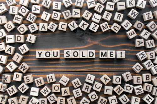 You sold me - phrase from wooden blocks with letters, you persuaded me concept, random letters around, white  background