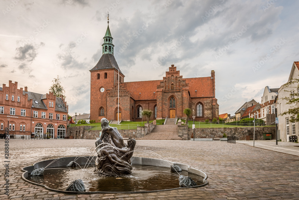 Φωτογραφία Vor Frue Kirke, Church  and fountain in the square of Svendborg against a grayis