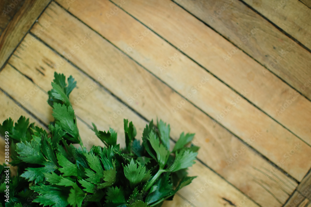 Bunch of fresh parsley celery on a wooden table. Healthy eating, raw food concept background. Fresh greens in the kitchen Bunch of fresh parsley celery on a wooden table. Healthy eating, raw food concept background. Fresh greens in the kitchen