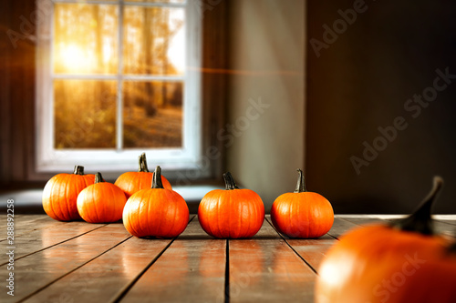 Autumn pumpkin on table and blurred background of window sill 