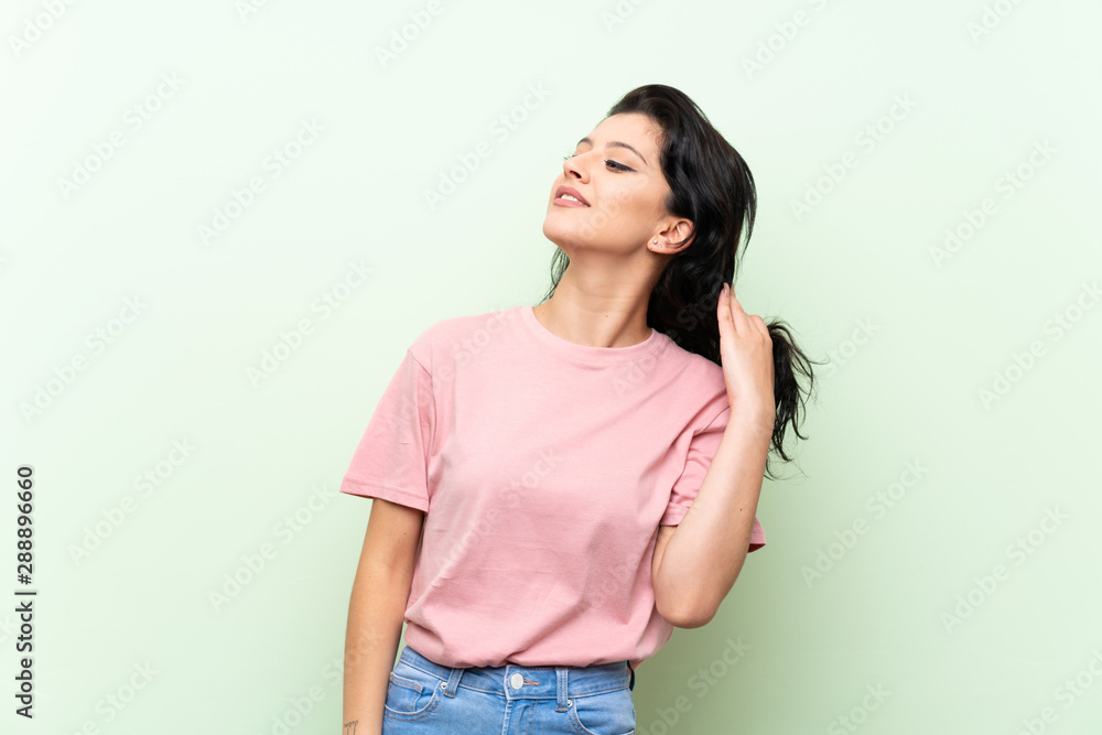 Young woman over isolated green background thinking an idea Young woman over isolated green background thinking an idea