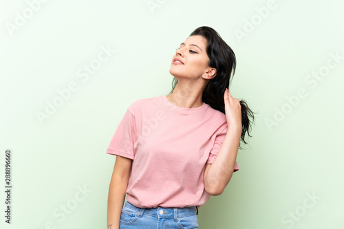 Young woman over isolated green background thinking an idea