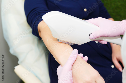 Hair depilation in the beauty salon. Laser hair removal on the arm.