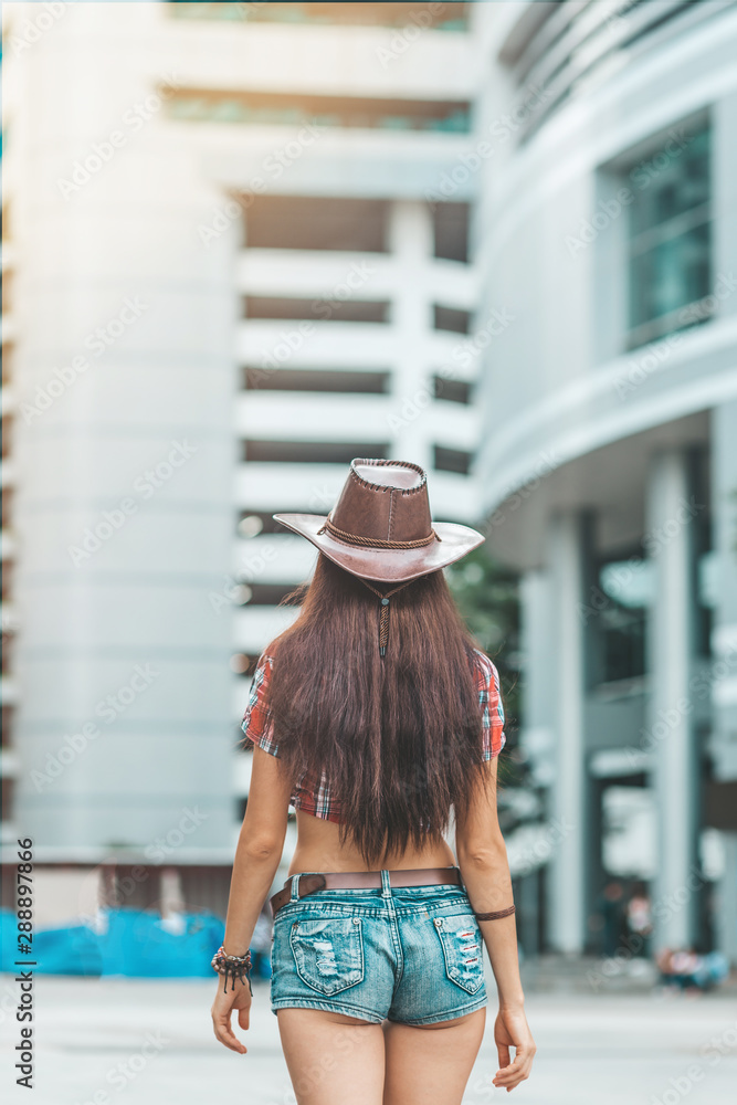 Portrait Of Young Woman In Denim Shorts And Cowboy Hat Country Girl Portrait Of Young Woman In Denim Shorts And Cowboy Hat Country Girl