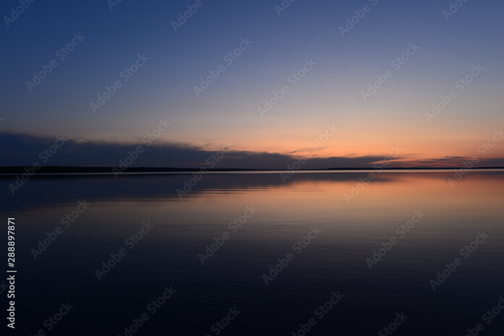 Blue sky in twilight over a mirrored calm surface of the lake
