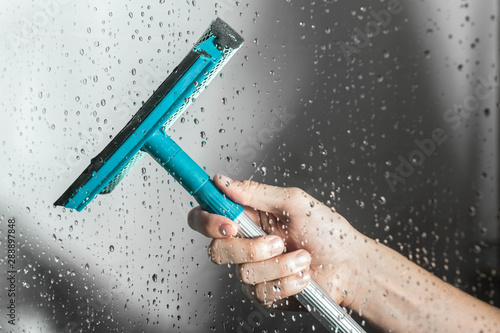 Quadro su tela close up cleaning shower glass door with squeegee