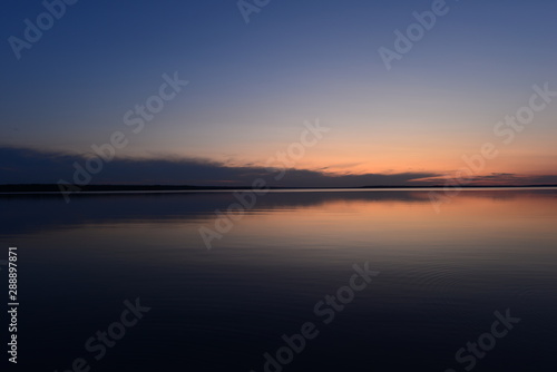 Blue sky in twilight over a mirrored calm surface of the lake